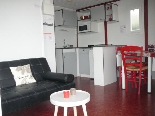 a living room with a couch and a table at Les Chalets des Mousquetaires in Mirepoix