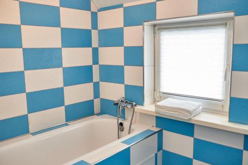 ヴィーンヌィツャにあるRiverの青と白のバスルーム(バスタブ付)、窓が備わります。