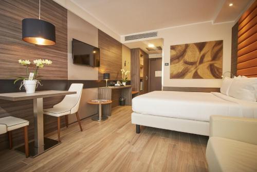 a bedroom with a bed and a table and a desk at iH Hotels Milano Lorenteggio in Milan