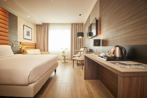 a hotel room with a bed and a desk at iH Hotels Milano Lorenteggio in Milan