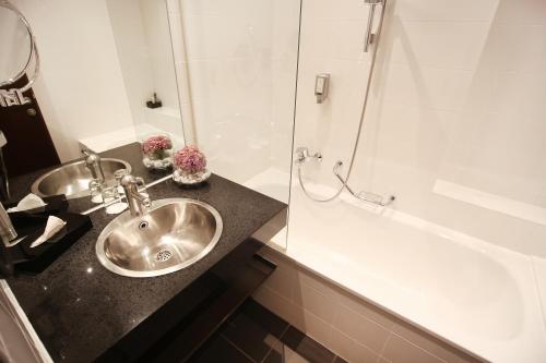 a bathroom with a sink and a bath tub at Schiller 5 Hotel in Munich