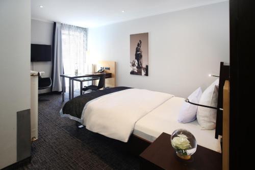 a hotel room with a bed and a desk at Schiller 5 Hotel in Munich