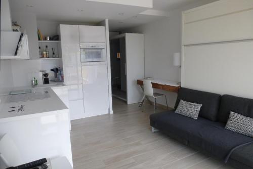 Il dispose d'une cuisine et d'un salon avec un canapé et une table. dans l'établissement Les Terrasses de la Mer, à Menton