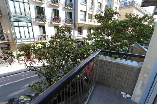 an apartment balcony with a tree in front of a building at Modern & spacious apartment near La Concha Bay in Donostia-San Sebastián