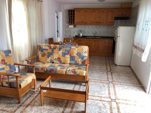 een woonkamer met een bank en een koelkast bij ÁTICO ESTRELLA in Tejina de Isora
