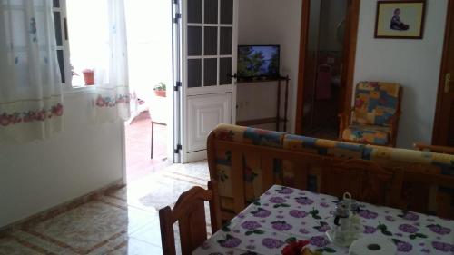 een woonkamer met een tafel en een bank bij ÁTICO ESTRELLA in Tejina de Isora