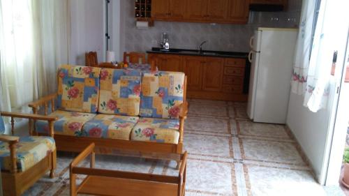 ein Wohnzimmer mit einem Sofa und einem Kühlschrank in der Unterkunft ÁTICO ESTRELLA in Tejina de Isora