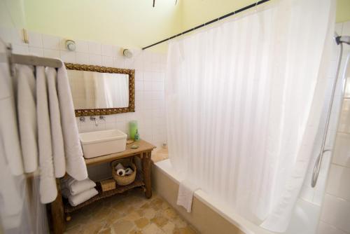 uma casa de banho com uma banheira, um lavatório e um espelho. em Desert Home em Mitzpe Ramon