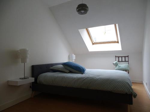 Un dormitorio con una cama y una ventana encima. en Le Loft, l'annexe, en Lorient