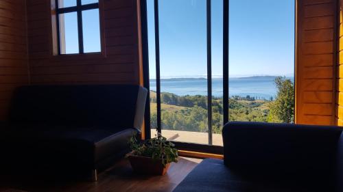 a living room with a couch and a large window at Cabaña Quiquel, Dalcahue, Chiloe in Dalcahue