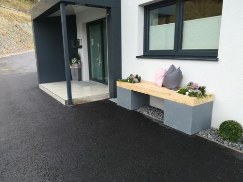 a house with a bench on the side of it at Appartement Gschwandtner in Eben im Pongau