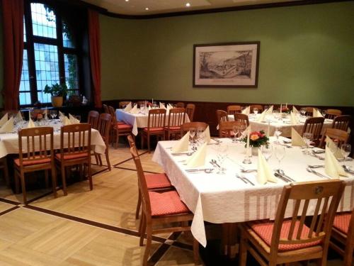 una sala da pranzo con tavoli e sedie bianchi di Löwen-Post ad Alpirsbach