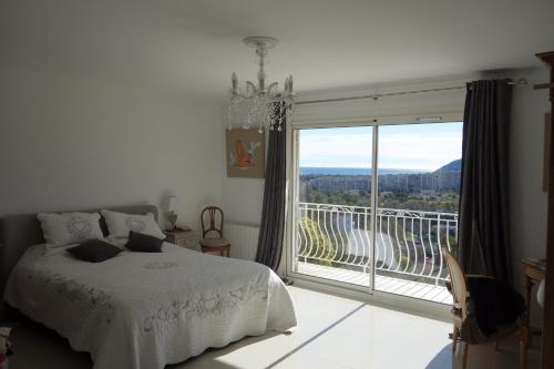 une chambre avec un lit et une grande fenêtre dans l'établissement Villa La Riviera, à Mandelieu-la-Napoule