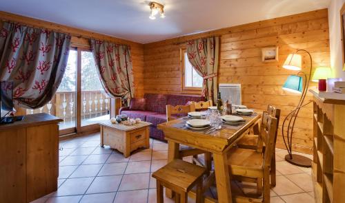 een woonkamer met een tafel en een bank bij CGH Résidences & Spas Orée Des Cimes in Peisey-Nancroix