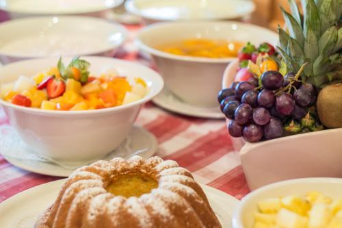 a table with plates of food and bowls of fruit at Hotel Sonnhof in Neustift im Stubaital