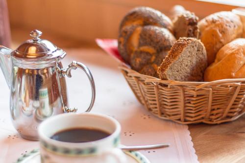 a basket of bread sitting next to a cup of coffee at Hotel Sonnhof in Neustift im Stubaital