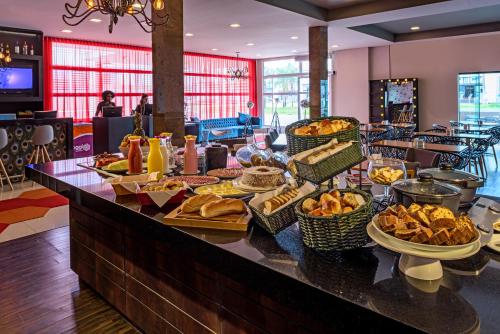 a buffet with bread and other food on a table at ibis Styles Ribeirao Preto Braz Olaia in Ribeirão Preto