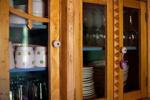 a cabinet with plates and cups in it at Grand Balaton House in Kővágóörs