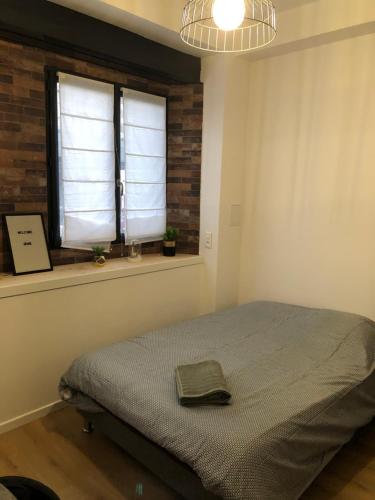 une chambre avec un lit et une fenêtre dans l'établissement Marguerite, à Strasbourg