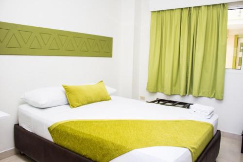 MangueにあるTerra Toscana Hotelのベッドルーム1室(緑のカーテン付きのベッド1台付)