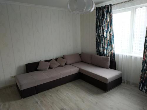 a couch in a living room with a window at Comfort Apartment on Bogdanivska street 7b in Kyiv