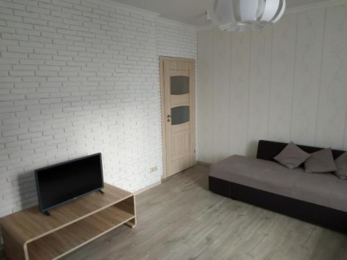 a living room with a couch and a flat screen tv at Comfort Apartment on Bogdanivska street 7b in Kyiv