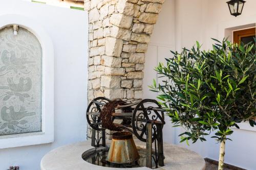 a table with a metal chair next to a plant at The Bridge House in Spílion