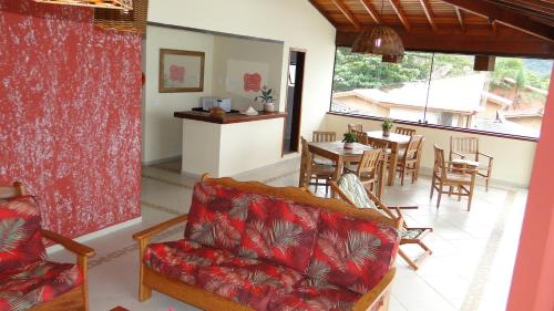 a living room with a couch and a table and chairs at Pousada Casa na Praia in Ubatuba