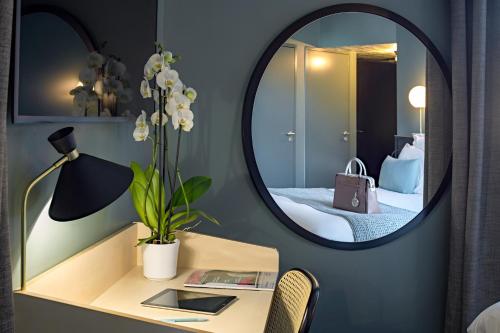 a room with a table with a mirror and a bed at Mercure Nantes Centre Passage Pommeraye in Nantes
