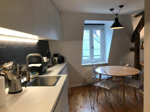 a kitchen with a sink and a table in it at Appartement Cocoon Hypercentre in Strasbourg