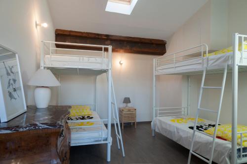 une chambre avec deux lits superposés et un bureau dans l'établissement Maison Borrel, à Carcassonne