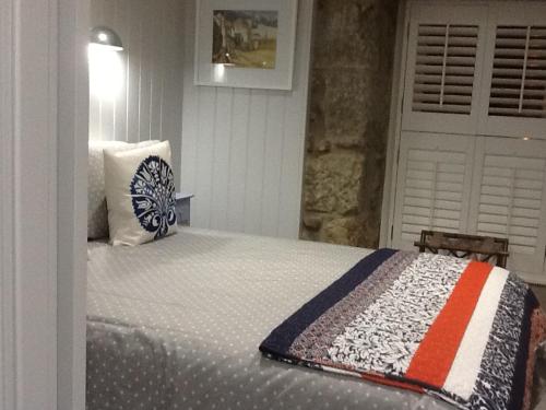 a bedroom with a bed with a quilt on it at Sunny Corner in Mousehole