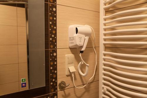 a phone hanging on a wall in a bathroom at Holiday-Darłówko in Darlowko