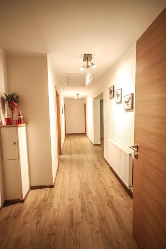 an empty hallway in an apartment with a hard wood floor at Landhaus zur Tanne in Feld am See