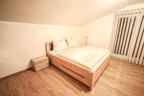 a bedroom with a bed and a wooden floor at Landhaus zur Tanne in Feld am See