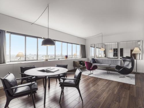 a living room with a table and chairs at Radisson Collection Royal Hotel, Copenhagen in Copenhagen