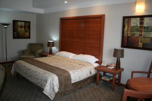 a hotel room with a bed and a chair at Royal Palace in Hermosillo