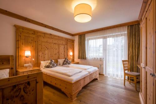 a bedroom with a bed and a desk and a window at Apart S'Dörfl in Mayrhofen