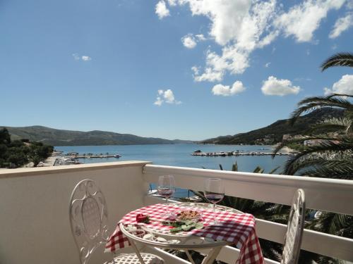 einen Tisch und Stühle auf einem Balkon mit Blick auf das Wasser in der Unterkunft Villa Samac in Trogir
