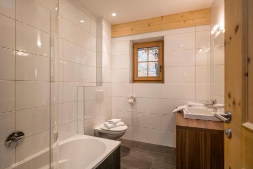 a bathroom with a tub and a toilet and a sink at Apart S'Dörfl in Mayrhofen