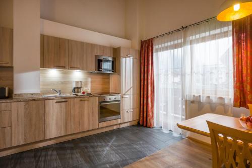 a kitchen with wooden cabinets and a table and a window at Apart S'Dörfl in Mayrhofen