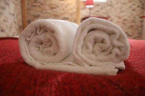 um rolo de toalhas sentado em cima de uma cama em Pro Touristic Montejunto Villas em Arieiro