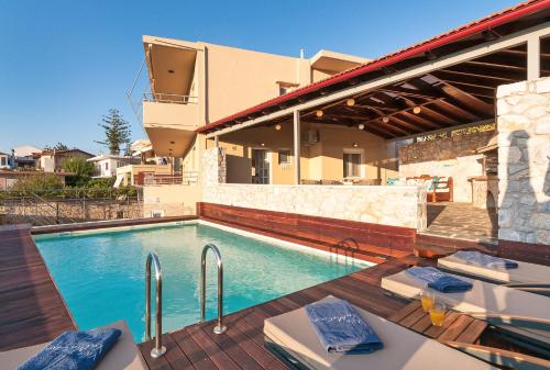 a swimming pool in front of a house at Villa Vamagia BY APOKORONAS-VILLAS in Plaka