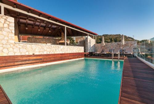 a swimming pool with chairs and a house at Villa Vamagia BY APOKORONAS-VILLAS in Plaka