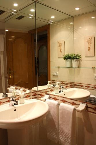 a bathroom with two sinks and a large mirror at Las Tres Sorores in Aínsa