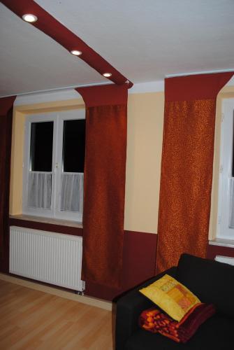 a living room with red curtains and a couch at CasaCreativa in Bad Windsheim