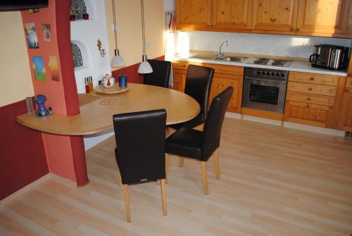 a kitchen with a wooden table and black chairs at CasaCreativa in Bad Windsheim