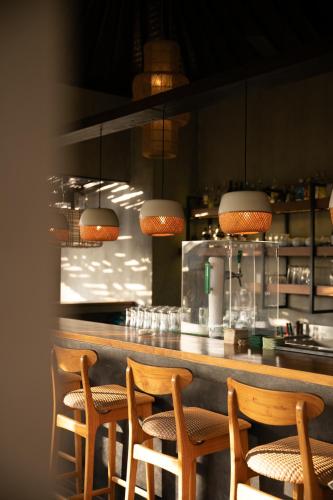 a bar with four chairs sitting at a counter at Wasabi in Canggu