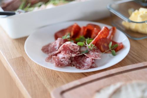 a plate of meat and vegetables on a table at First Hotel The Studio in Stockholm
