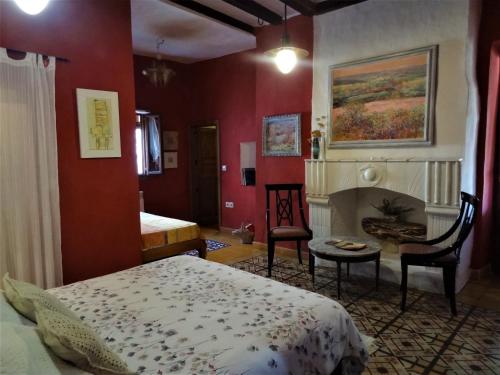 a bedroom with red walls and a bed and a fireplace at La Solana, alojamiento y alfarería in Arenas de San Pedro